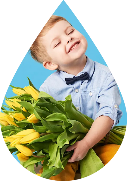 Petit garçon qui porte un bouquet de fleurs